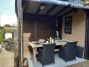 een houten tafel en stoelen op een patio bij Bed & Breakfast De Schans in Makkum