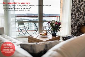 Nordica Design Residence Rovaniemi في روفانييمي: غرفة معيشة مع أريكة وطاولة مع زهور