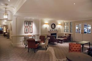 uma sala de estar com cadeiras e mesas e uma lareira em Durrants Hotel em Londres