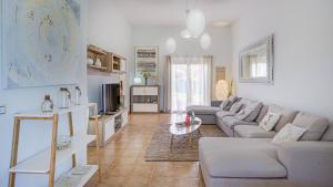 ein Wohnzimmer mit einem Sofa und einem Tisch in der Unterkunft Villa Fortuna in Caleta de Fuste