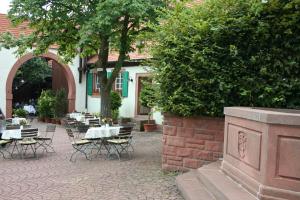 eine Gruppe von Tischen und Stühlen im Innenhof in der Unterkunft Landhotel Sickinger Hof in Walldorf