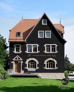 uma casa preta com um telhado vermelho em Mittermeiers Alter Ego em Rothenburg ob der Tauber