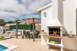 a patio with a fireplace next to a swimming pool at Villas Isi & Ana Mestral in Cala en Blanes