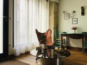 a living room with a glass table and a chair at LE COSY LOIRE appart in Les Rosiers