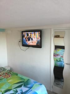 a tv on a wall in a room with a bed at little ibiza in Zandvoort