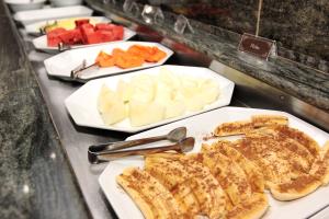 a buffet with several plates of cheese and other foods at Sumatra Hotel e Centro de Convenções in Londrina