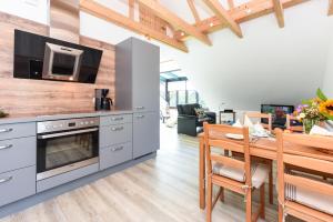 eine Küche mit einem Holztisch und einem Esszimmer in der Unterkunft Jever-Ferienhaus Himmelsblick in Jever