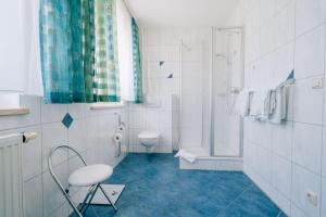 ein weißes Badezimmer mit Toilette und Dusche in der Unterkunft Hotel Abenstal in Au in der Hallertau + 46 Fotos