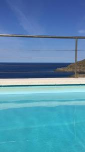 a pool of blue water with the ocean in the background at Barca Serena in Port de la Selva