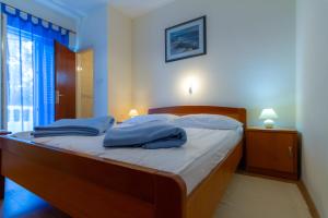 a bedroom with a bed with blue pillows on it at Apartman Haus Maja in Banjol