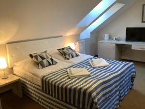 a bedroom with a bed with two towels on it at Amberia Mikołajki in Mikołajki