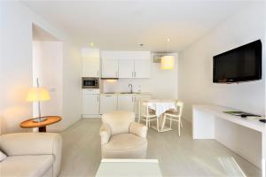 un soggiorno bianco con divano e tavolo di Amazonia Estoril Hotel a Estoril