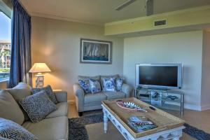 a living room with a couch and a tv at Oceanfront Retreat Modern Living on Miramar Beach in Destin