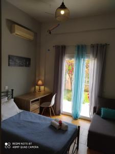 Schlafzimmer mit einem Bett, einem Schreibtisch und einem Fenster in der Unterkunft Summer Village House Popi in Kanakádes