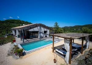 a villa with a swimming pool and a house at Maison d'hôtes Thym et Chocolat in Générargues