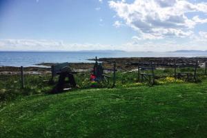 Arctic House by the sea, Vadsø, Varanger في فادسو: طاولة نزهة على الشاطئ مع المحيط في الخلفية