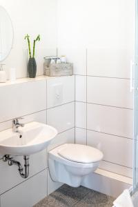 een witte badkamer met een toilet en een wastafel bij City Studio Apartment for 2, near Sonnenallee in Berlijn