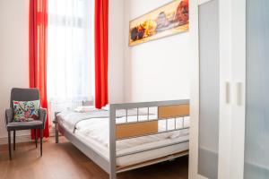 a small bedroom with a bed and a chair at City Studio Apartment for 2, near Sonnenallee in Berlin