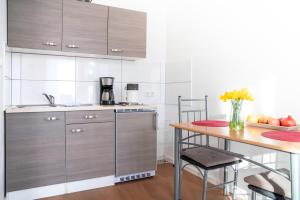 een keuken met roestvrijstalen kasten en een houten tafel bij City Studio Apartment for 2, near Sonnenallee in Berlijn