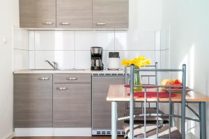 una cucina con tavolo in legno e piano di lavoro di City Studio Apartment for 2, near Sonnenallee a Berlino