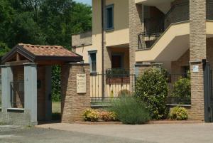 ein Backsteingebäude mit einem Tor und einem Balkon in der Unterkunft Residence San Prospero in Garbagnate Milanese