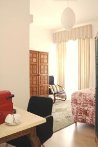 a room with a table and chairs and a bedroom at 6/4 de Sado in Setúbal