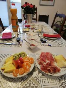 una mesa con platos de fruta encima en Chez Cathy chambre chez l'habitante, en Bremis