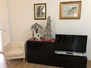 ein Wohnzimmer mit einem TV und einem Stuhl in der Unterkunft Casa Magnolia in Pastrengo