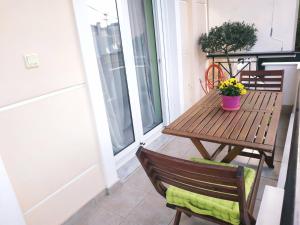 Un porche con una mesa de madera y un banco. en JIMMY'S HOUSE, en Artemida