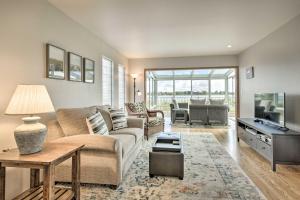 ein Wohnzimmer mit einem Sofa und einem Tisch in der Unterkunft Ideally Located San Francisco Bay Home with Sunroom! in Alameda