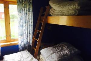 a bunk bed with a ladder next to a window at Grandfathers house at the end of Europe, Varanger in Havningberg