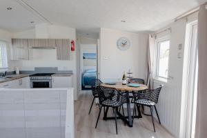a kitchen and dining room with a table and chairs at Noordkop vakanties in Westerland