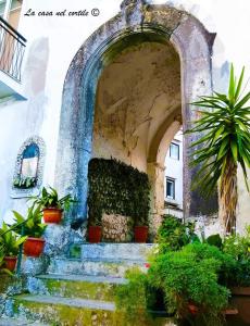 ein Torbogen mit einer Treppe in einem Gebäude mit Pflanzen in der Unterkunft La Casa nel Cortile in Vico Equense