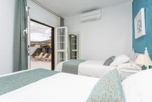 MácherにあるVilla Angelaのベッド2台とバルコニーが備わるホテルルームです。
