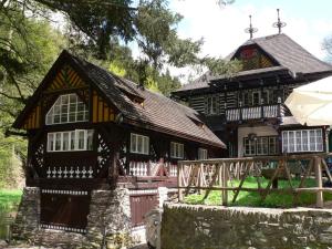a large wooden house with a fence in front of it at Vakantiehuis Cerny Dul 38 in Černý Dŭl