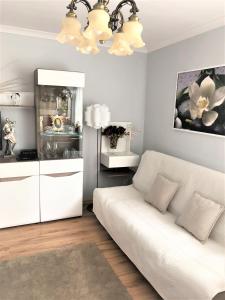 salon z białą kanapą i białą szafką w obiekcie Ania w Ustce