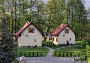 una casa con techo de paja y entrada en Domki letniskowe Yaga, en Wilkasy