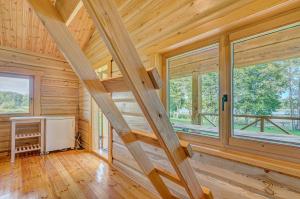 a log cabin with wooden ceilings and windows at Sauna with the Private Lake Access in Molėtai