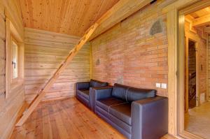 a living room with a couch and a brick wall at Sauna with the Private Lake Access in Molėtai