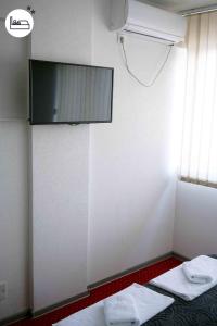 Cette chambre comprend 2 lits et une télévision murale. dans l'établissement Rooms S&S Milicevic u strogom centru Aleksandrovca, à Aleksandrovac