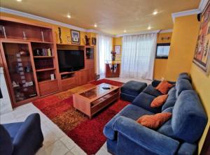 a living room with a blue couch and a tv at villa Santa Ana in Laredo