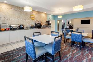 a kitchen with a table, chairs, and a refrigerator at La Quinta by Wyndham Kerrville in Kerrville