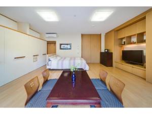 a room with a bed and a table and chairs at Shinjuku Garden House / Vacation STAY 81151 in Tokyo