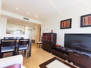 sala de estar con TV grande y cocina en PORT GRAN - MAJESTIC - ROSES - COSTA BRAVA en Rosas