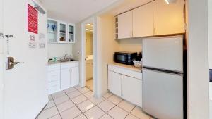 uma cozinha com armários brancos e um frigorífico em Ocean view studio with direct beach access and a shared pool & tennis court! em Miami Beach