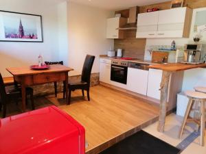 een keuken en eetkamer met een tafel en een bureau bij Baumhaus Freiburg in Freiburg im Breisgau