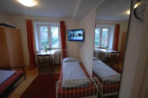 Habitación con 2 camas y TV en la pared. en Airportgästehaus Bremen en Bremen