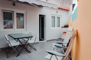 patio con mesa y sillas en el balcón en Casa Janelas da Fonte Nova en Setúbal