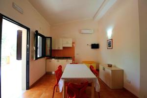 a kitchen with a table and chairs in a room at Zagare Residence in Rodi Garganico