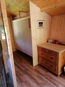Zimmer in einer Hütte mit Holzkommode in der Unterkunft Baumhaus Freiburg in Freiburg im Breisgau